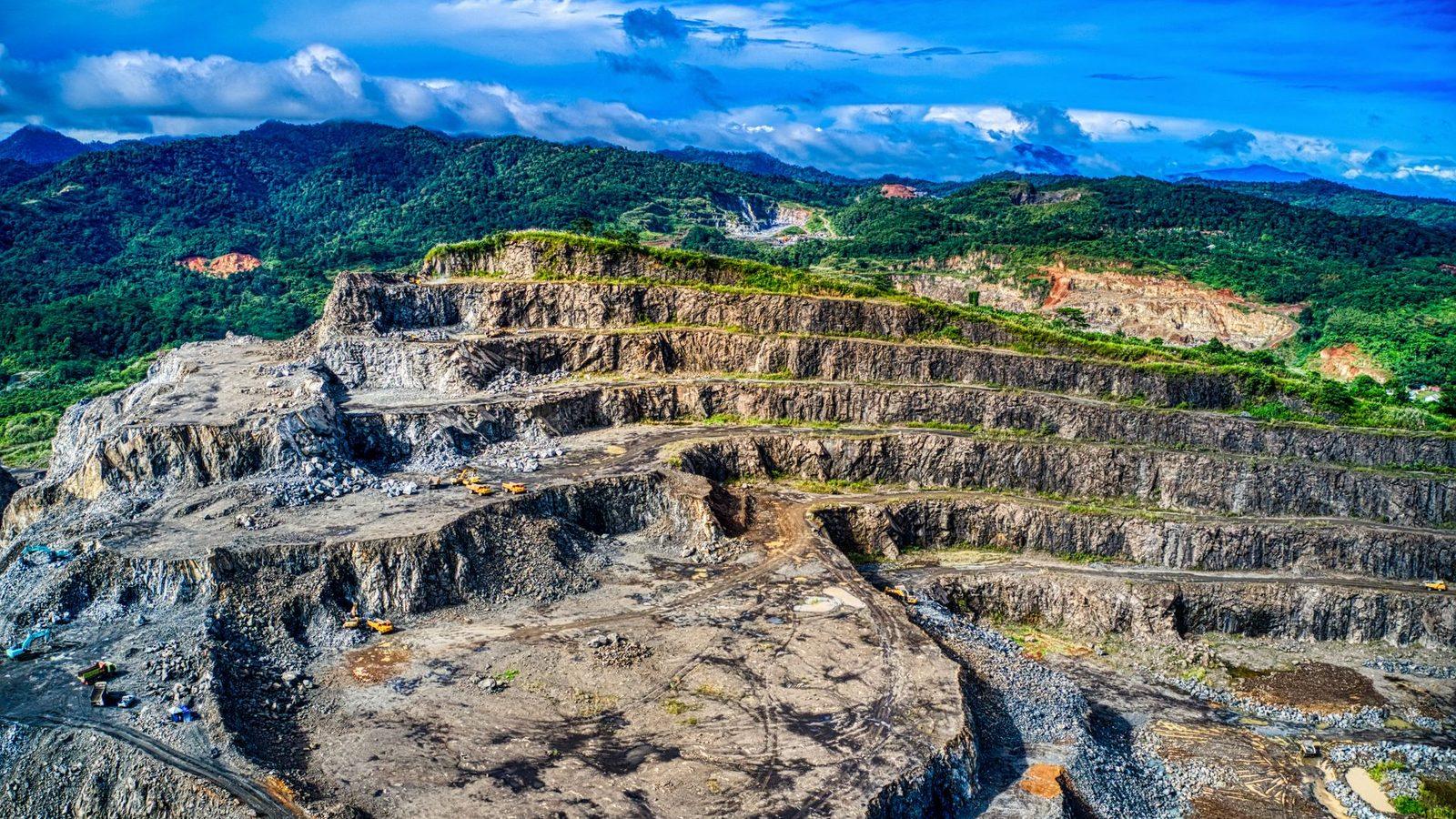 Open-pit mine cut into forested hills